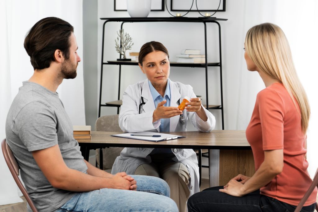 Doctor consulting couple in medical office.