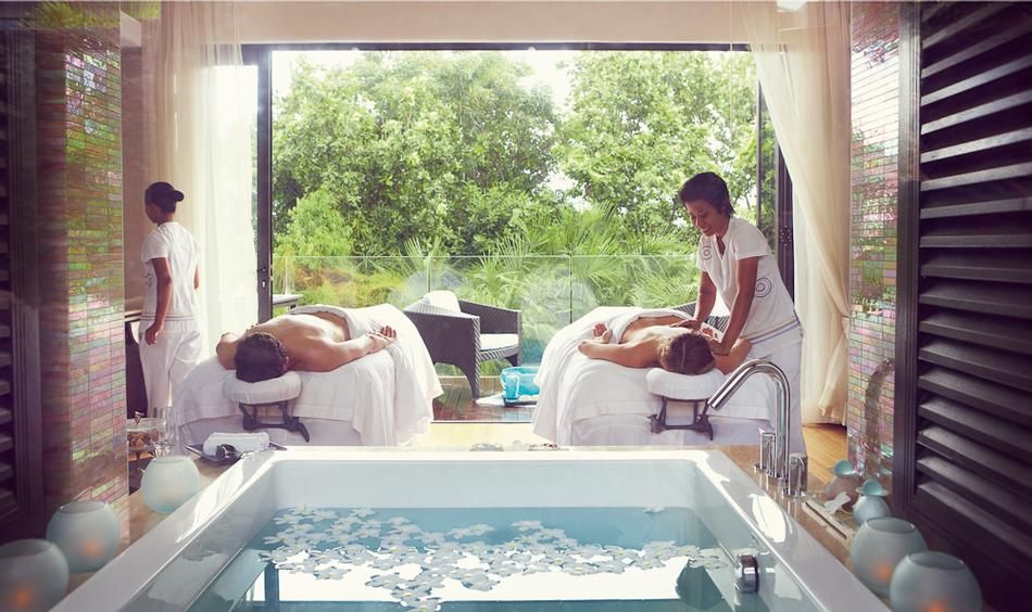 Couples spa massage with outdoor view.