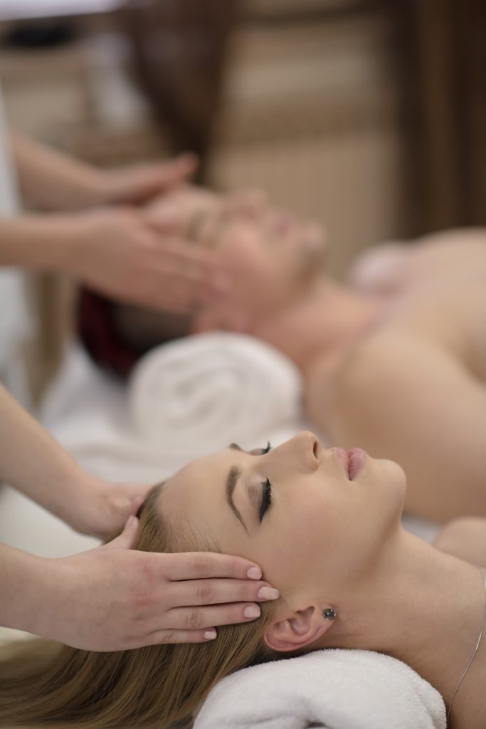 Couple receiving relaxing head massages together.