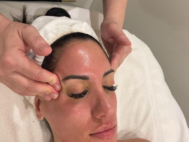 Woman receiving a facial massage treatment.