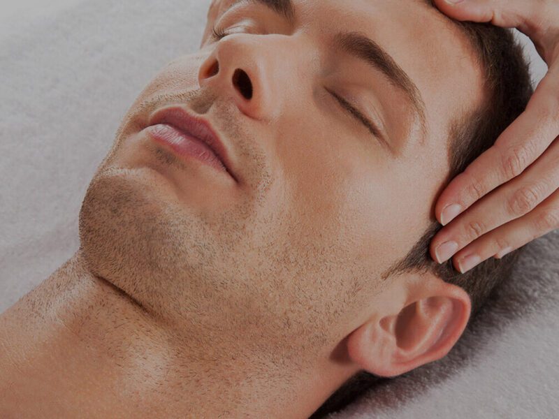 Man receiving relaxing head massage therapy.