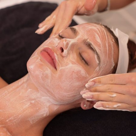 Woman receiving facial mask spa treatment