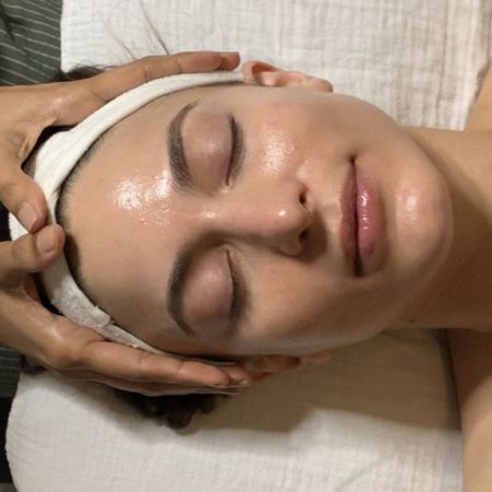 Person receiving facial massage at spa